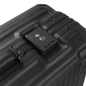 Close-up of a black hard-shell suitcase showing its TSA combination lock and textured ridge design