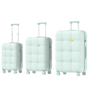 Set of three light green suitcases of different sizes on a white background