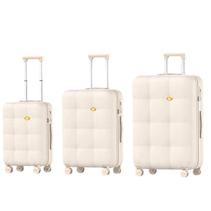 Three cream-colored suitcases of different sizes on a white background