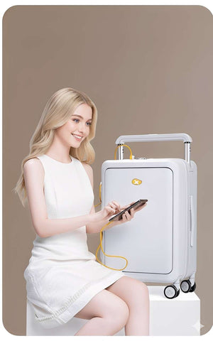 Woman in a white dress sitting next to a white suitcase with a phone in her hand on a beige background