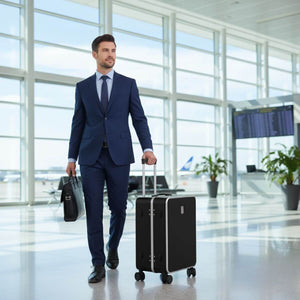 Business traveler walking through airport with Nordiva Classic black suitcase
