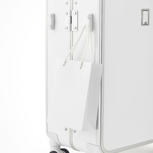 White suitcase with a white paper bag attached to it on a white background
