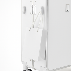 White suitcase with a white paper bag attached to it on a white background