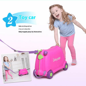 Little girl pulling a pink BabyYuga ride-on suitcase like a toy car, smiling and running while holding the purple strap.