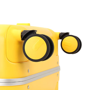 Close-up of the yellow suitcase’s dual spinner wheels showing the black-and-yellow wheel design and corner mounting.