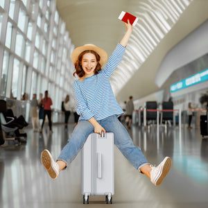 Woman sitting on a suitcase in an airport, holding a red passport