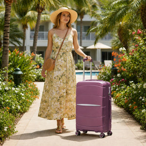 Traveller with a Purple Fortiva 55cm carry-on suitcase at a resort