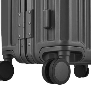 Close-up of a black hard-shell suitcase showing its 360° spinner wheels, reinforced corner base, and textured ridge design.