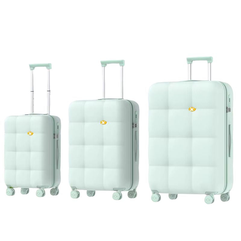 Set of three light green suitcases of different sizes on a white background