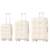 Three cream-colored suitcases of different sizes on a white background