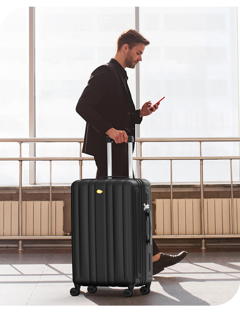 Man with a black suitcase and smartphone in an airport setting