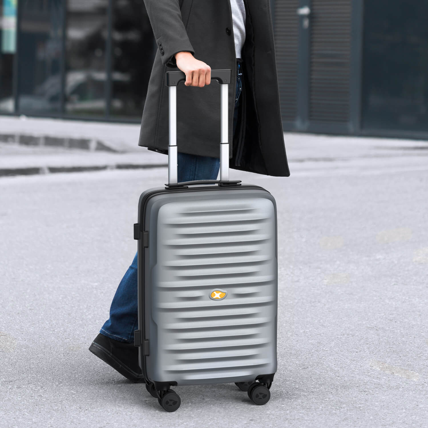 Person holding a silver suitcase with a blurred background