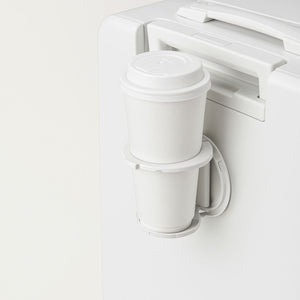 Built-in cup holder on white suitcase holding two takeaway coffee cups.