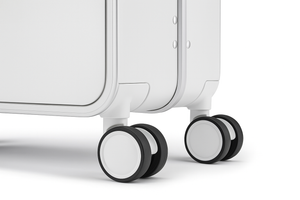 Close-up of a white suitcase with black wheels on a light gray background