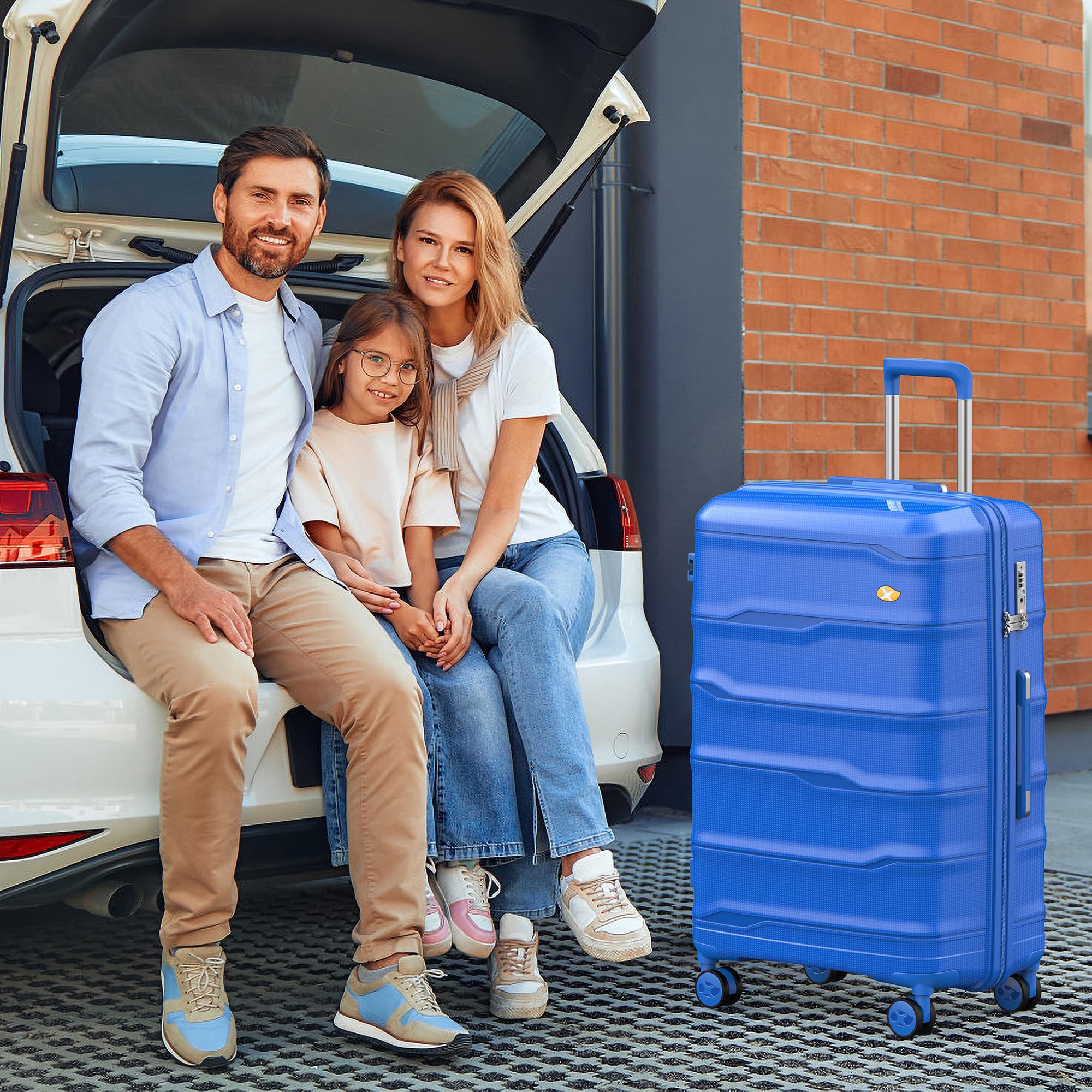Family sitting by an open car trunk with a blue suitcase next to them.